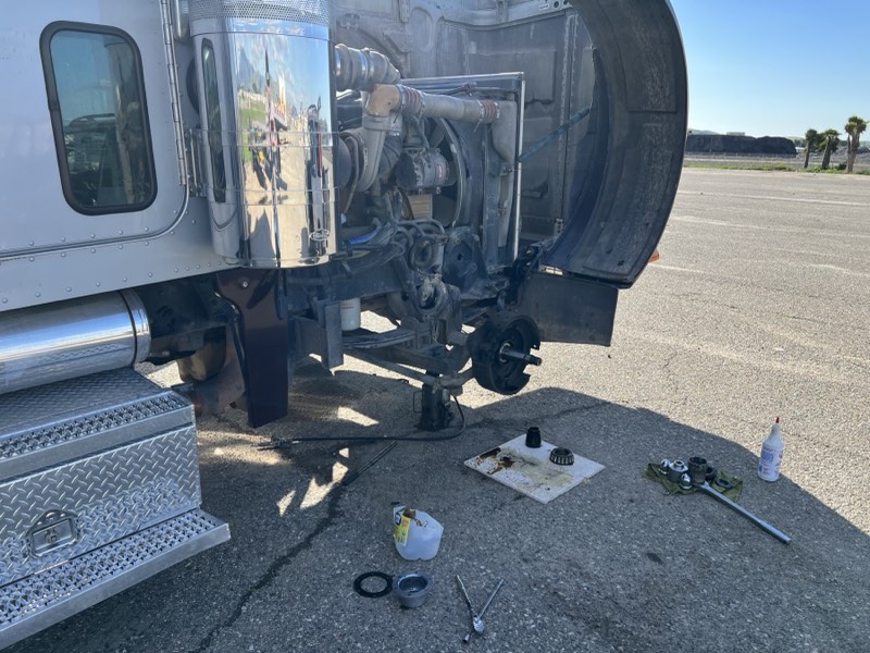 Peterbilt truck with front wheel removed for a wheel bearing job in the field